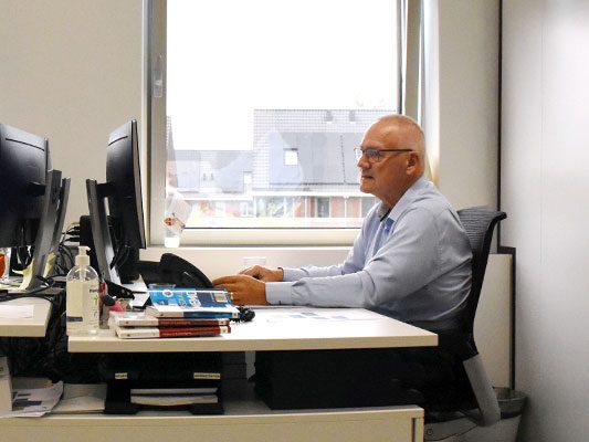 Medewerker aan het werk achter een bureau op het kantoor in Badhoevedorp